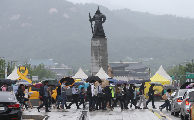 장맛비가 내리는 서울 광화문 건널목에서 시민들이 우산을 쓴 채 출근길을 재촉하고 있다. 신소영 기자 viator@hani.co.kr