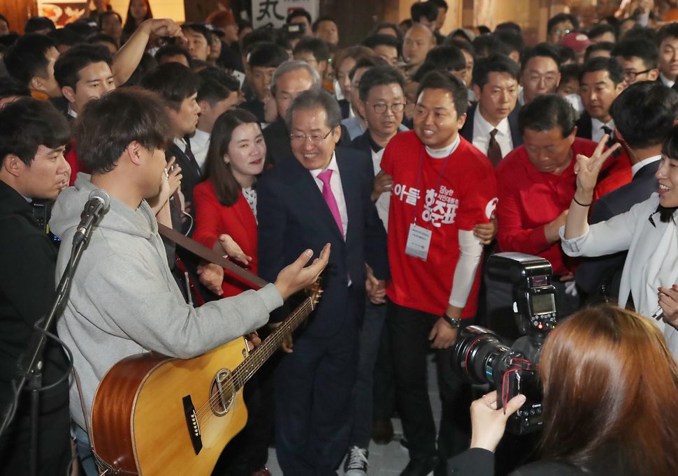 홍준표 자유한국당 대선 후보가 선거일을 하루 앞둔 8일 저녁 서울시 마포구 홍대 인근에서 선거운동을 벌이다가 거리 공연 중인 청년에게 다가가고 있다. 연합뉴스