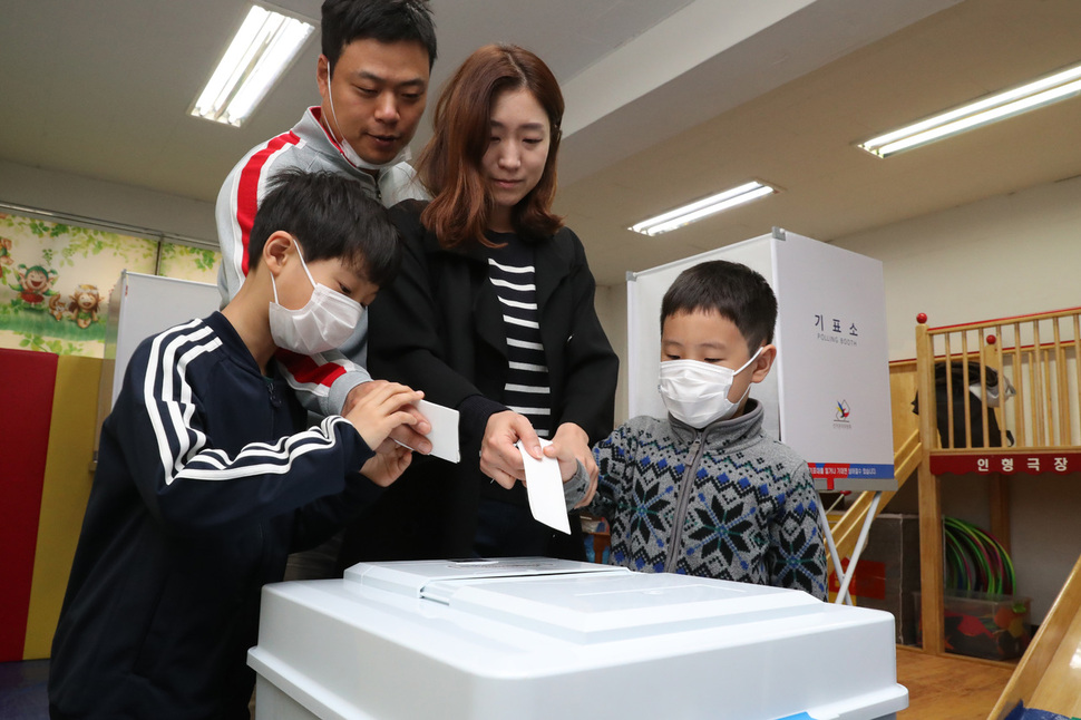 제19대 대통령 선거일인 9일 오전 서울 영등포구 여의동 윤중초등학교에 마련된 여의동제6투표소를 찾은 시민이 자녀와 함께 투표지를 투표함에 넣고 있다. 이정아 기자 leej@hani.co.kr