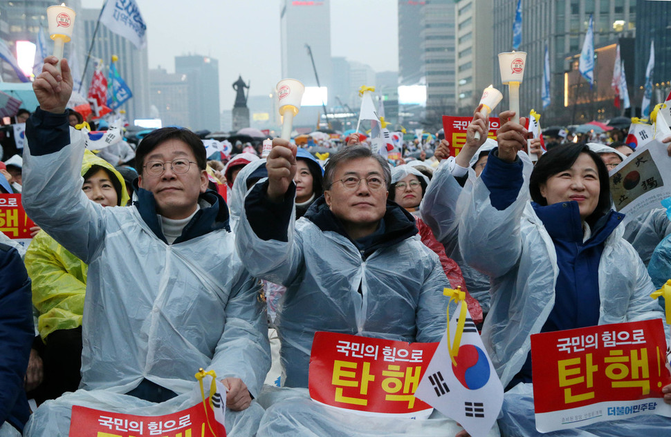 더불어민주당 대선 경선 중이던 지난 3월1일 저녁 서울 광화문광장에서 열린 박근혜 대통령 탄핵 촉구 촛불집회에서 문재인 당시 경선 후보(가운데)와 이재명 후보(왼쪽)가 일본군 ‘위안부’ 피해자 이용수 할머니의 연설을 들으며 촛불을 치켜들고 있다. 오른쪽은 추미애 당 대표. 이정우 선임기자 woo@hani.co.kr