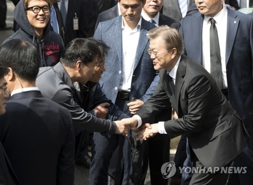 문재인 대통령이 10일 오전 서울 서대문구 홍은동 자택을 나서며 주민들로부터 당선 축하를 받고 있다. 연합뉴스