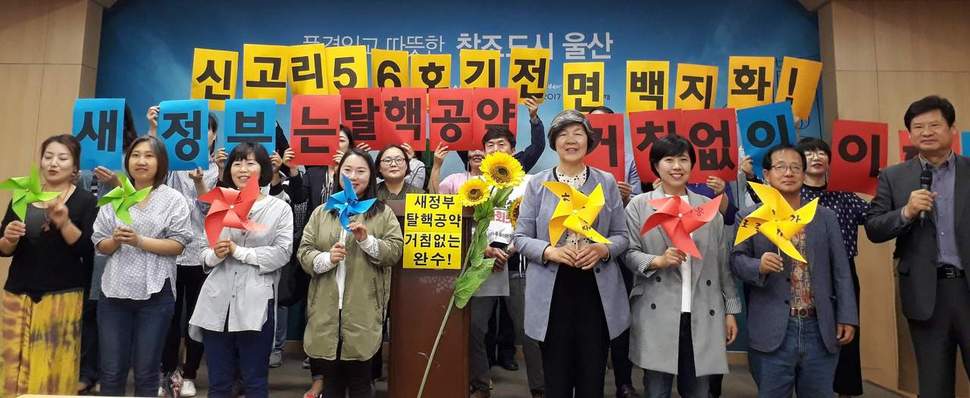 탈핵울산시민공동행동이 문재인 대통령과 새 정부에 탈핵공약 이행을 촉구하며 재생에너지를 상징하는 해바라기와 바람개비 등을 들어보이고 있다.