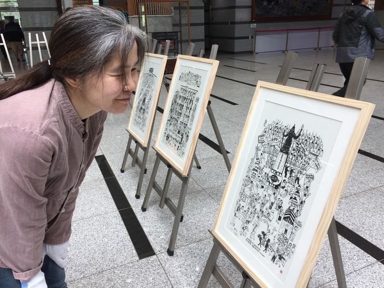 원주시청에서 18일까지 열리는 5.18민중항쟁 37돌 기념 판화·사진전에서 15일 한 시민이 김봉준 작가의 ‘촛불시민 국민주권자 행진도1’을 관심 있게 보고 있다. 원주시민연대 제공