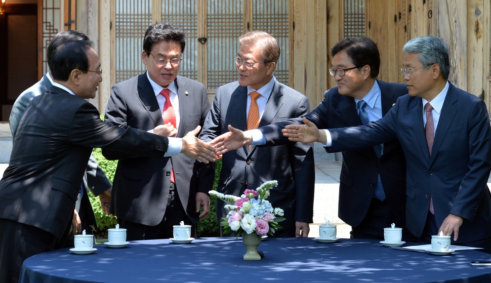 19일 청와대 상춘재에서 열린 문재인 대통령과의 오찬회동에 참석한 여야원내대표들이 대통령을 사이에 두고 서로 악수를 하고 있다. 청와대사진기자단