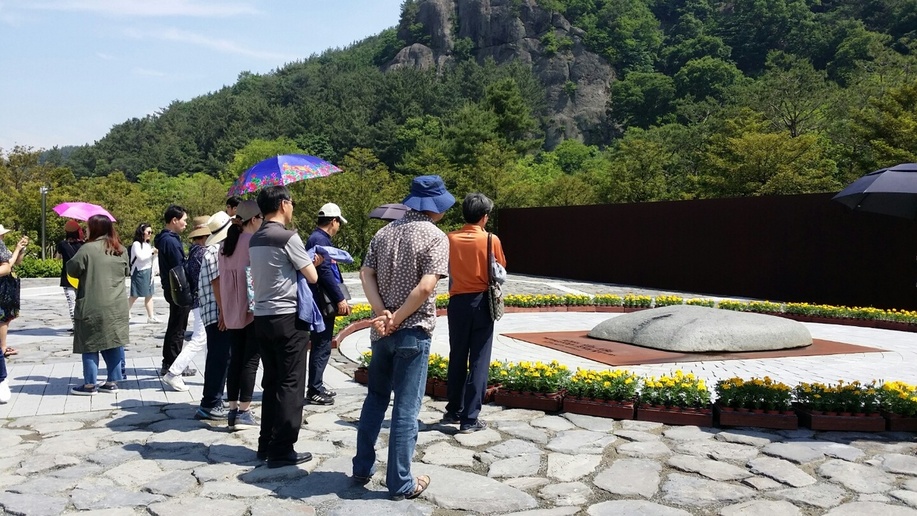 21일 경남 김해시 진영읍 봉하마을의 노무현 대통령 묘역에서 참배객들이 노 전 대통령이 잠들어 있는 너럭바위를 바라보고 있다.