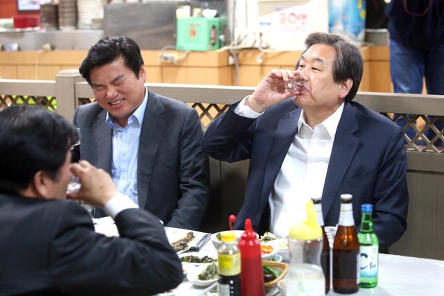 지난해 3월 새누리당 김무성 대표가 24일 오후 부산 중구 자갈치시장에서 원유철 원내대표와 식사를 하면서 소주를 마시고 있다. 연합뉴스