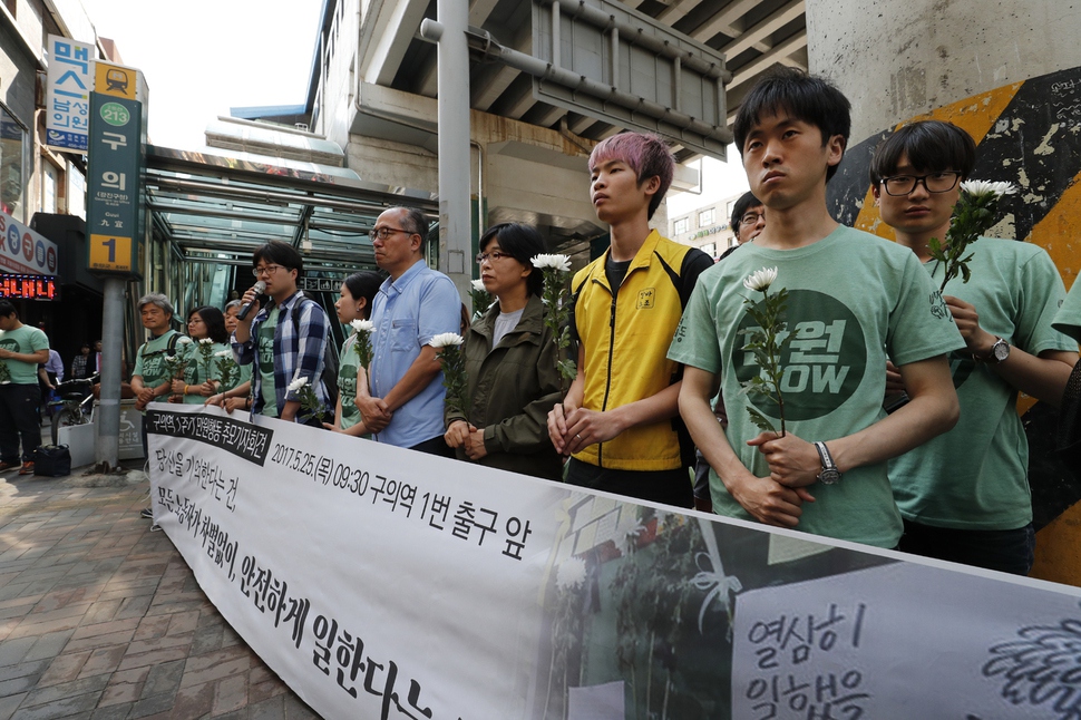 구의역 스크린도어 사고 1주기를 앞두고 25일 오전 서울 광진구 구의역 앞에서 '만원공동행동' 회원들이 기자회견을 열고 김군을 추모하며 국화를 들고 있다. 박종식 기자 anaki@hani.co.kr