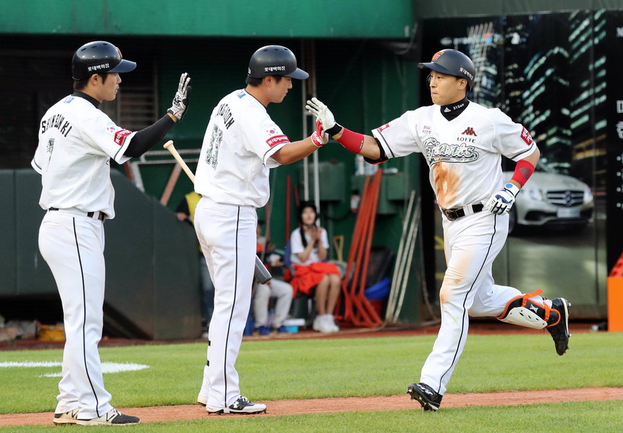 롯데 손아섭(오른쪽)이 4일 부산 사직구장에서 열린 케이티(kt)와의 프로야구 경기에서 5-7로 뒤진 4회말 동점 2점 홈런을 터뜨린 뒤 동료들의 축하를 바고 있다. 부산/연합뉴스
