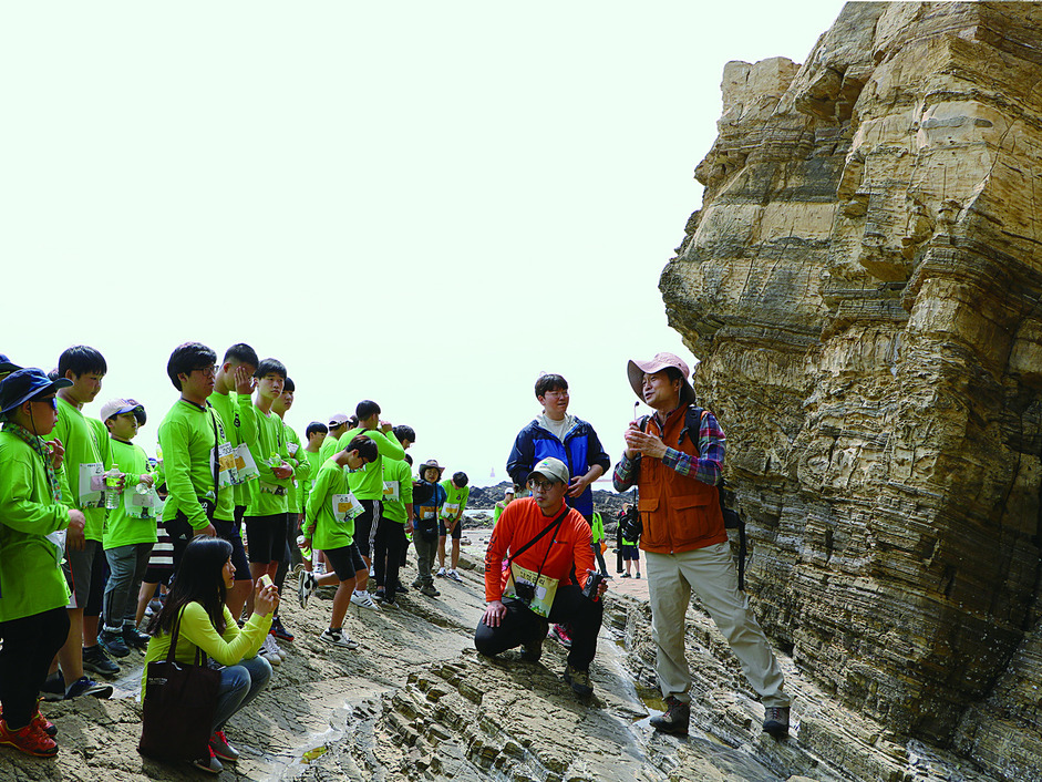 <한겨레> 조홍섭 환경전문기자가 국립공원 50주년 기념 행사로 지난달 20일 변산반도에서 열린 ‘명사와 함께하는 힐링로드 걷기’에 참가한 청소년들에게 적벽강의 지질학적 가치에 대해 설명하고 있다. 환경부 제공