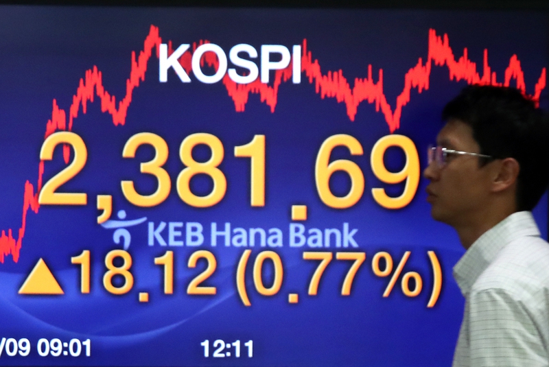 코스피가 18.12 오른 2381.69로 마감하며 또 사상 최고치를 기록한 9일 오후 서울 중구 을지로 케이이비(KEB)하나은행 본점 딜링룸에서 한 직원이 전광판 앞을 지나고 있다. 연합뉴스