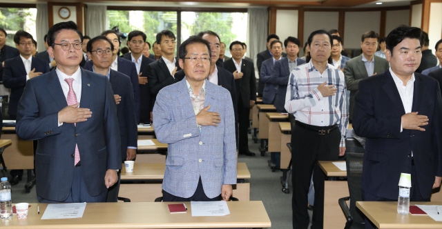 자유한국당 당 대표 경선에 출마한 홍준표 전 경남지사(앞줄 가운데)가 지난 15일 오후 서울 여의도 중소기업중앙회에서 열린 자유한국당 원외당협위원장협의회 전체회의에서 국민의례를 하고 있다. 당 대표 경선에는 홍 전 지사와 원유철 의원(앞줄 오른쪽), 신상진 의원이 등록했다. 강창광 기자 chang@hani.co.kr