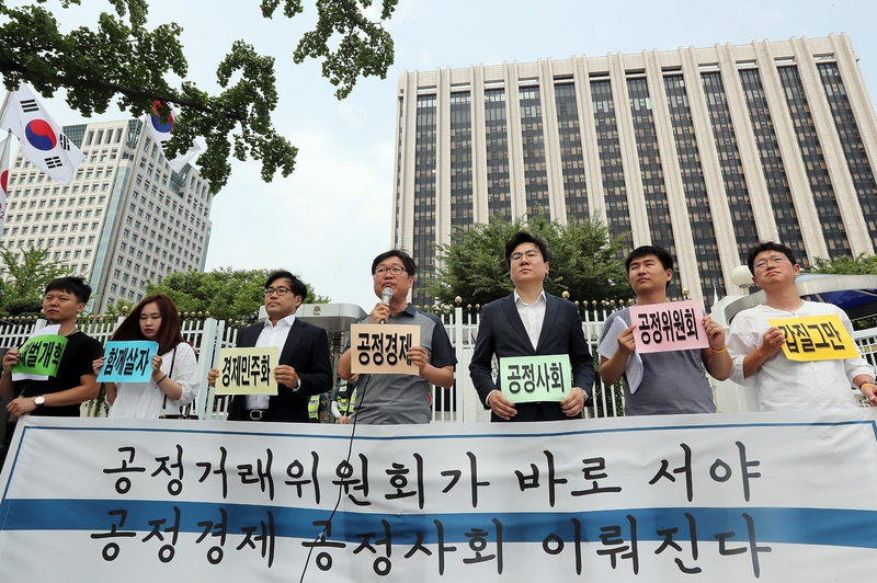21일 오전 서울 정부서울청사 앞에서 열린 기자회견에서 경제민주화전국네트워크와 참여연대 관계자들이 경제민주화 실현 등 7대 과제를 공정거래위원회에 제시하고 있다. 연합뉴스