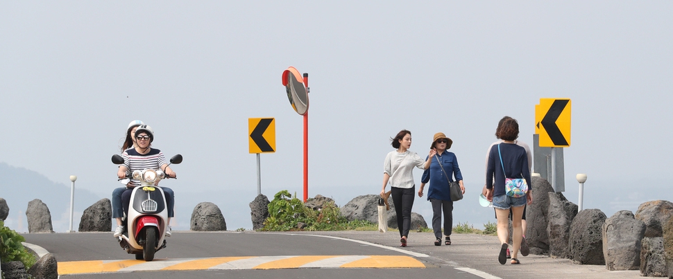 제주도 우도면 서빈백사홍조단괴 해수욕장 부근에서 관광객들이 스쿠터를 타거나 도보여행을 하고 있다.                우도/김봉규 기자 bong9@hani.co.kr