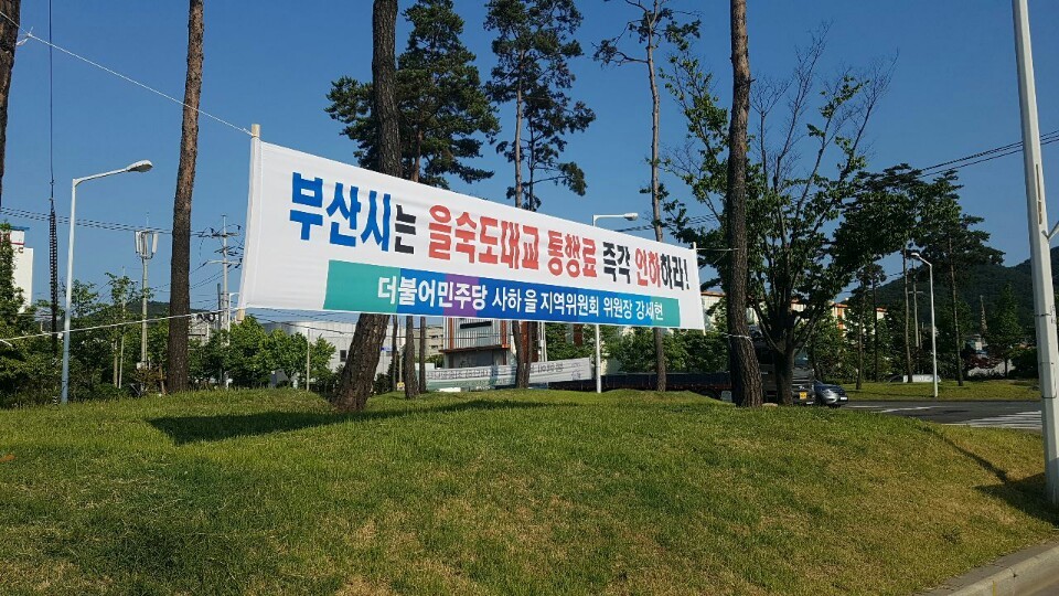 부산 사하구을 지역위원회가 사하구에 을숙도대교 통행료 인하를 촉구하는 펼침막을 내걸었다.더불어민주당 부산 사하구을 지역위원회 제공