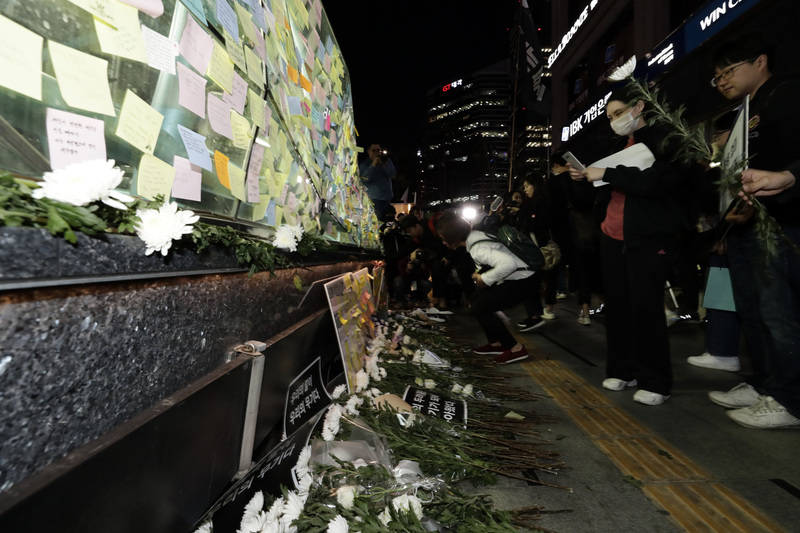 강남역 여성살해사건 1주기 추모행동 행사가 열린 17일 저녁 참가자들이 강남역 10번 출구에서 희생자를 추모하는 의미로 국화를 헌화하고 포스트잇을 붙이고 있다. 한겨레 자료사진