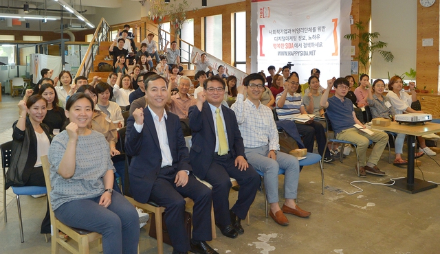 고창국 SK C&C 상무(앞줄 왼쪽에서 두번째)와 구자덕 비영리IT지원센터 이사장(세번째) 등이 28일 ‘행복한 사이다’ 포털 오픈 행사를 마친 뒤 화이팅을 외치고 있다. SK C&C 제공