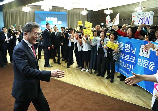 문재인 대통령이 5일(현지시각) 독일 베를린에서 열린 동포 오찬 간담회에 입장하고 있다. 노란색 바탕에 “세월호 진상규명 지지합니다”라고 쓰인 손팻말을 들고 있는 동포들이 문 대통령을 환영하고 있다. 청와대 제공