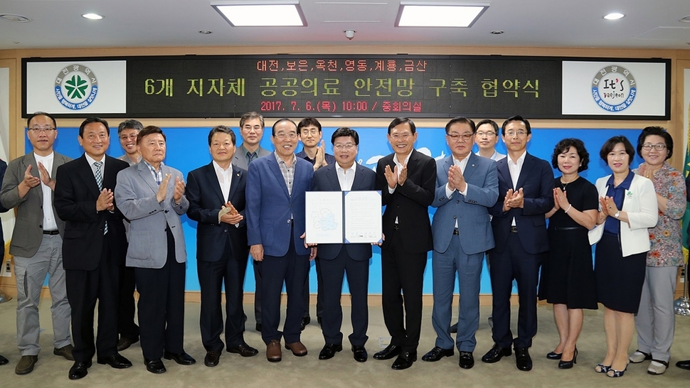 권선택 대전시장(가운데 협약서 펼쳐 든 이)이 6일 오전 대전시청 회의실에서 계룡시와 옥천·보은·영동·금산군과 공공의료 안전망 구축 및 재난 공동대응 협약을 한 뒤 시·군 단체장 및 관계자들과 함께 협약서를 공개하고 있다. 대전시 제공