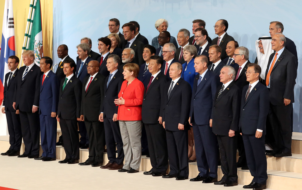 문재인 대통령을 비롯한 G20 각국 정상들이 7일 오후(현지시간) 주요 20개국(G20) 정상회의가 열리는 독일 함부르크 메세에서 기념촬영을 하고 있다. 앞줄 왼쪽부터 엠마누엘 마크롱 프랑스 대통령, 도널드 트럼프 미국 대통령, 조코 위도도 인도네시아 대통령, 엔리케 뻬냐 니에또 멕시코 대통령, 제이콥 게드레이레키사 주마 남아공 대통령, 마우리시오 마끄리 아르헨티나 대통령, 앙겔라 메르켈 독일 총리, 시진핑 중국 국가주석, 블라디미르 푸틴 러시아 대통령, 레젭 타입 에르도안 터키 대통령, 미세우 떼메르 브라질 대통령, 문재인 대통령. 둘째 줄 왼쪽부터 알파 콤데 기니 대통령, 파울로 젠틸로니 실베리 이탈리아 총리, 저스틴 트뤼도 캐나다 총리, 나렌드라 모디 인도 총리, 아베 신조 일본 총리, 말콤 턴불 호주 총리, 테레사 메이 영국 총리, 도날드 투스크 EU 정상회의 상임의장, 장 클로드 융커 EU 집행위원장. 세째 줄 왼쪽부터 안토니오 쿠테흐스 UN 사무총장, 에르나 솔베르그 노르웨이 총리, 마크 루터 네덜란드 총리, 마키 살 세네갈 대통령, 리센룽 싱가포르 총리, 마리아노 라호이 브레이 스페인 총리, 응웬 쑤언 푹 베트남 총리, 이브라힘 알아사프 사우디아라비아 재무장관, 앙헬 구리아 OECD 사무총장. 네째 줄 왼쪽부터 호베르토 아제베도 WTO사무총장, 테드로스 아디아놈 WHO 사무총장, 크리스틴 라가르드 IMF 총재, 가이 라이더 ILO 사무총장, 김용 세계은행 총재, 마크 카니 FSB 의장.  연합뉴스