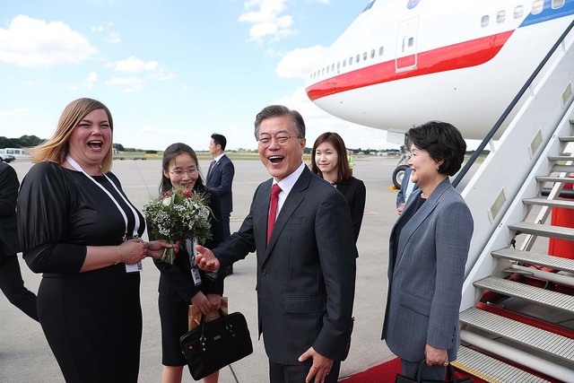 6일 함부르크 슈미트 공항에서 현지관계자가 가져온 환영꽃다발을 건네 받으려던 문재인 대통령이 “대통령 부인께 드릴 꽃다발”이라는 설명에 멋쩍어하며 크게 웃음을 터뜨리고 있다. 청와대사진기자단.