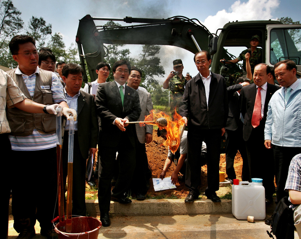 2007년 6월 국회 환경노동위원회 소속 의원들이 경기 파주 미군기지 ’캠프 에드워드’에서 지하수를 떠 나무에 묻힌 뒤 불을 붙였다. 파주/이종근 기자 root2@hani.co.kr