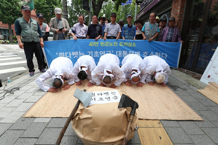 ‘내가 만드는 복지국가’와 노년유니온, 노후희망유니온 등 ‘빈곤노인 기초연금 보장을 위한 연대’ 소속 단체 회원들이 13일 오전 서울 종로구 청운효자동주민센터 앞에서 “‘줬다 뺏는 기초연금’ 해결하라”며 ‘도끼상소’ 행위극을 하고 있다. 김정효 기자 hyopd@hani.co.kr