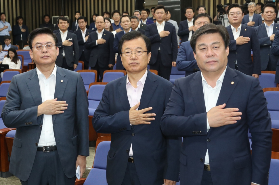 자유한국당 정우택 원내대표(왼쪽부터)와 이현재 정책위의장, 김선동 원내수석부대표 등 의원들이 14일 국회에서 열린 의원총회에서 국기에 대한 경례를 하고 있다. 연합뉴스.