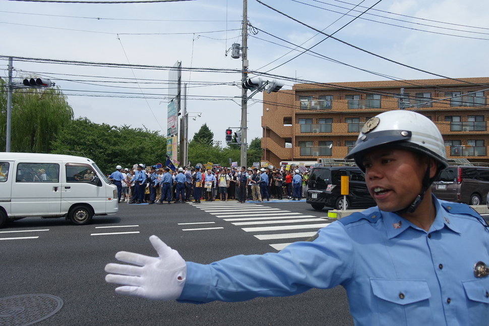 16일 일본 가나가와현 가와사키시 평화공원 인근 도로에서 경찰이 헤이트 스피치 반대 시위에 나선 시민들에 대해서 교통 통제를 하고 있다.