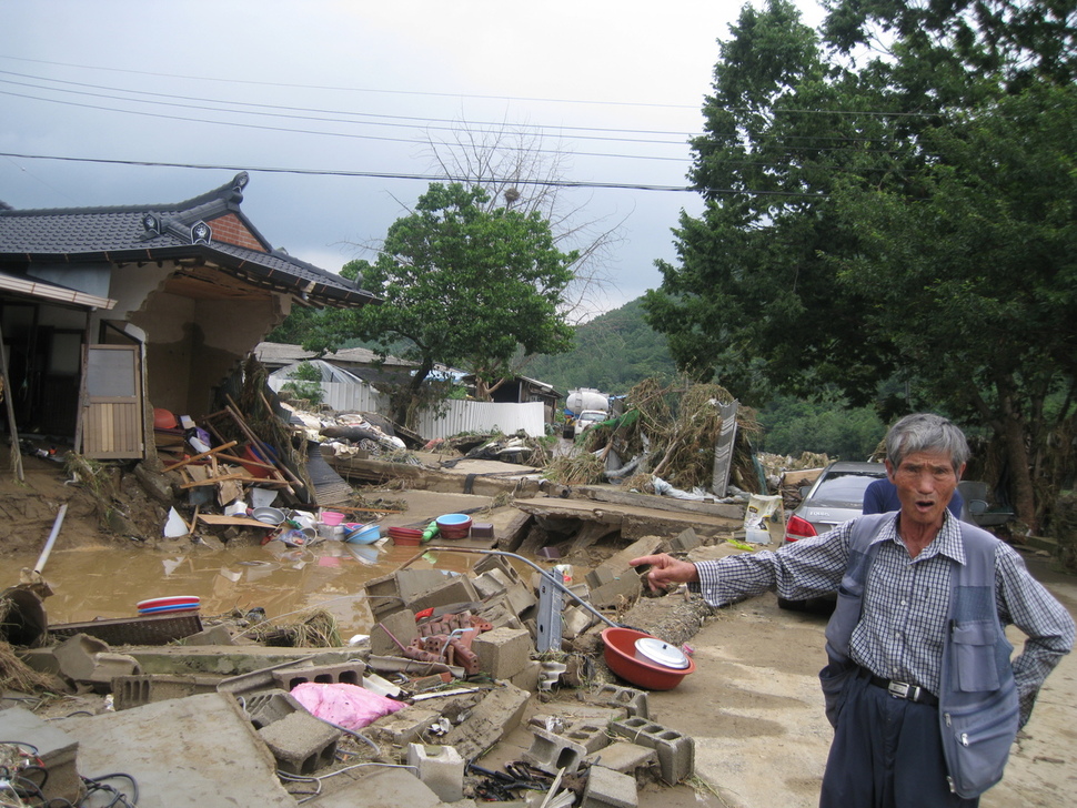 충북 청주시 미원면 운암리 박장규씨가 17일 낮 수해로 집이 쓸려 내려간 현장을 가리키며 절규하고 있다. 오윤주 기자