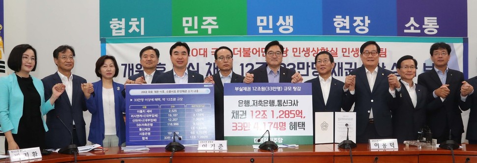 더불어민주당 우원식 원내대표 등 여당 의원들과 시중 5대은행 여신담당 부행장이 18일 오전 국회에서 열린 ‘부실채권 소각 보고대회’를 연 뒤 손을 맞잡고 포즈를 취했다. 연합뉴스