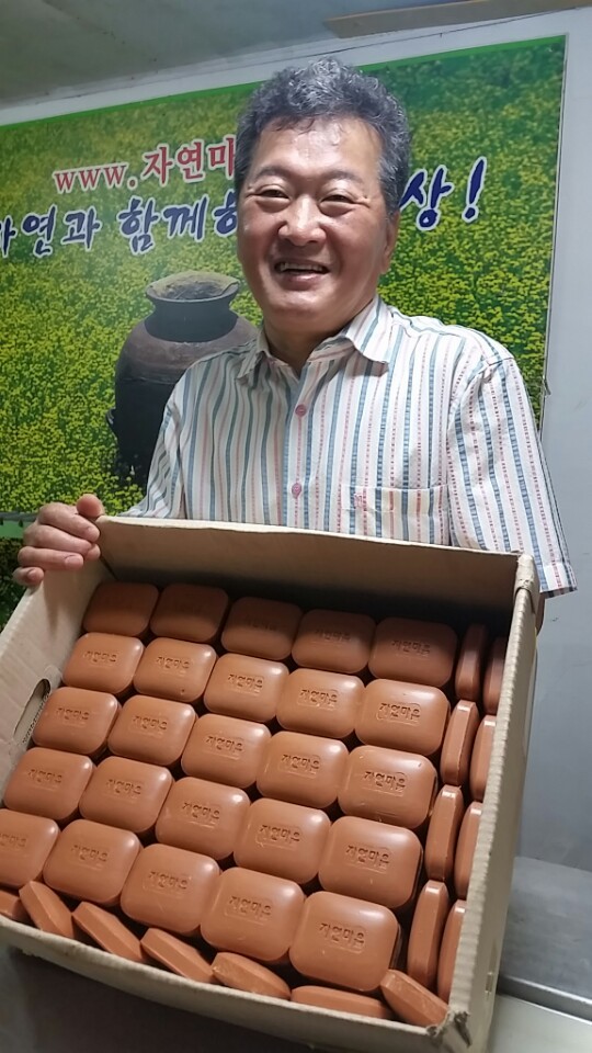 김강렬 시민생활환경회의 이사장이 광주에코센터가 생산한 비누를 들어 보이며 활짝 웃고 있다.