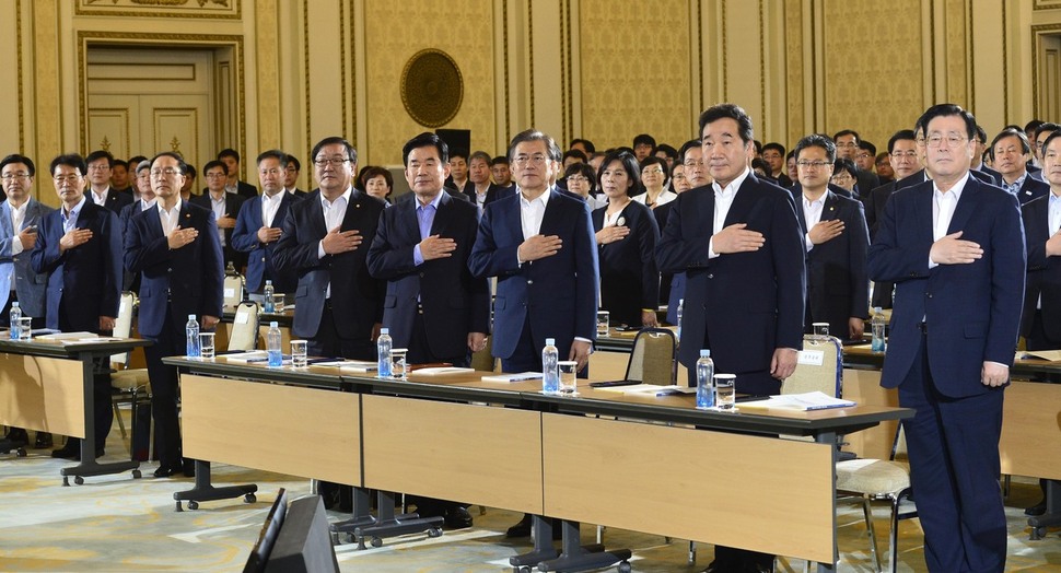 문재인 대통령과 참석자들이 19일 청와대 영빈관에서 열린 국정과제 보고대회에서 국민의례를 하고 있다. 청와대사진기자단