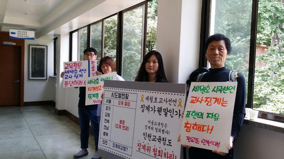 지난 19일 세월호 사건과 관련해 시국선언에 참여한 교사 징계를 위해 징계위원회가 소집된 인천 남부교육청에서 시민과 교사들이 징계 철회를 요구하며 팻말시위를 하고 있다. 전교조 인천지부 제공