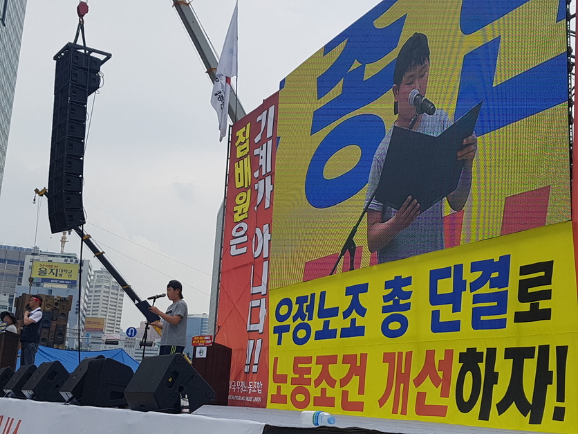 22일 전국우정노동조합이 서울 중구 서울광장에서 ‘전국 우정노동자 총궐기대회’를 열고 “집배원 과로사를 근절하고 부족인력을 충원하라”고 요구했다. 집배원 노동자의 자녀 박성균(13)군이 올라 문재인 대통령에 전달하는 편지를 낭독하고 있다.
