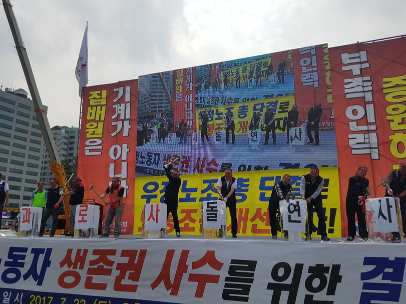 22일 전국우정노동조합이 서울 중구 서울광장에서 ‘전국 우정노동자 총궐기대회’를 열고 “집배원 과로사를 근절하고 부족인력을 충원하라”고 요구했다. 우정노조 조합원들이 무대에 올라 ‘과로사’, ‘돌연사’가 한 글자씩 적힌 얼음을 깨부수는 퍼포먼스를 진행하고 있다.