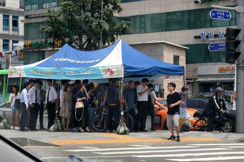 건널목 신호를 기다리는 시민들이 천막 그늘에서 따가운 햇볕을 피하고 있다. 2017년 7월 12일 서울 경복궁역 사거리. 강재훈 선임기자 khan@hani.co.kr