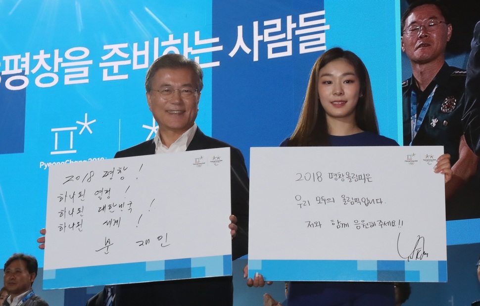 김연아가 지난 24일 평창 알펜시아 리조트에서 열린 ‘G-200, 2018, 평창을 준비하는 사람들’ 행사에서 문재인 대통령과 응원 메시지를 들어 보이고 있다. 평창/연합뉴스