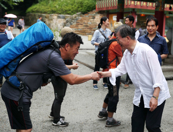 문재인 대통령이 휴가 둘째날인 31일 평창군 진부면 상원사 등산로에서 만난 시민들과 악수하고 있다. 청와대 제공