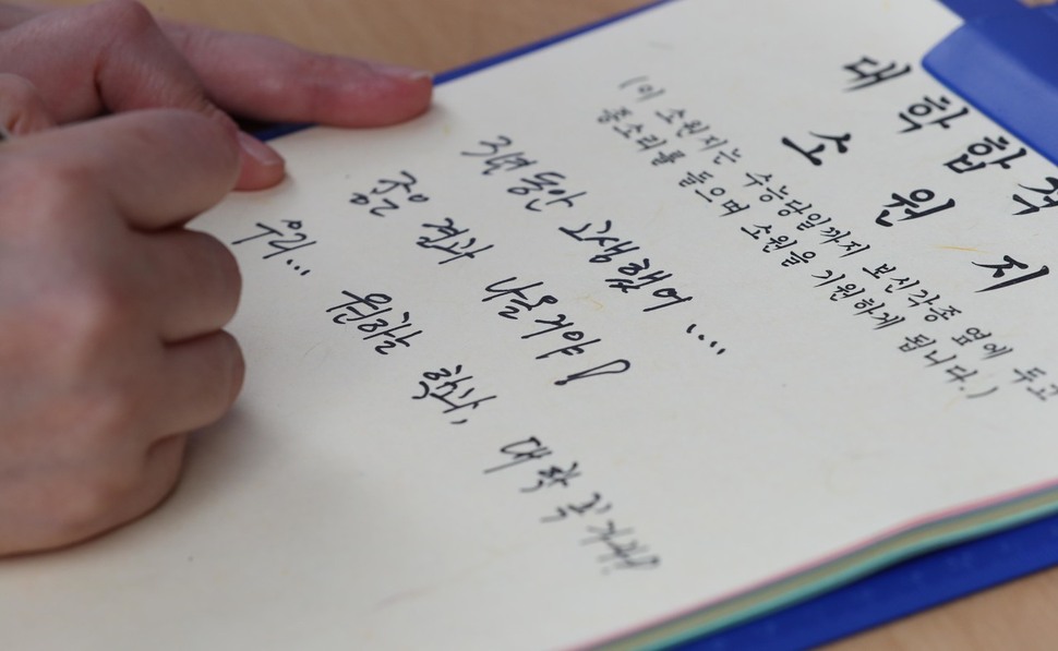 대학수학능력시험을 100일 앞둔 8일 오전 서울 종로구 보신각에서 열린 대학 합격기원 타종행사에서 수험생 자녀를 둔 한 학부모가 대학합격 소원지에 소원을 적고 있다. 백소아 기자 thanks@hani.co.kr