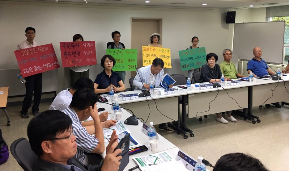 지난 8일 오후 ‘김포~관산도로 민·관·정 협의체’ 구성을 위한 간담회가 열린 경기도 고양시 일산동구청 소회의실에서 고양시민들이 ‘고봉산 터널 반대’가 적힌 손팻말을 들고 시위를 하고 있다.  고봉산터널반대 고양시민대책위원회 제공