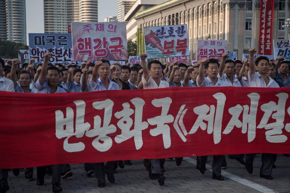 북한 시민들이 9일 평양 김일성광장에서 미국에 반대하고 북한의 입장을 지지하는 슬로건을 들고 주먹을 뻗으며 거리를 행진하고 있다. 연합뉴스