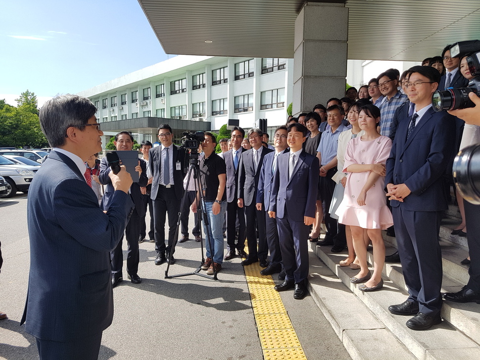 대법원장 후보자로 지명된 김명수 춘천지방법원장이 25일 별도의 이임식 없이 법원 현관에서 직원들과 기념사진을 찍은 뒤 마이크를 들고 이임 인사를 하고 있다. 춘천지방법원 제공