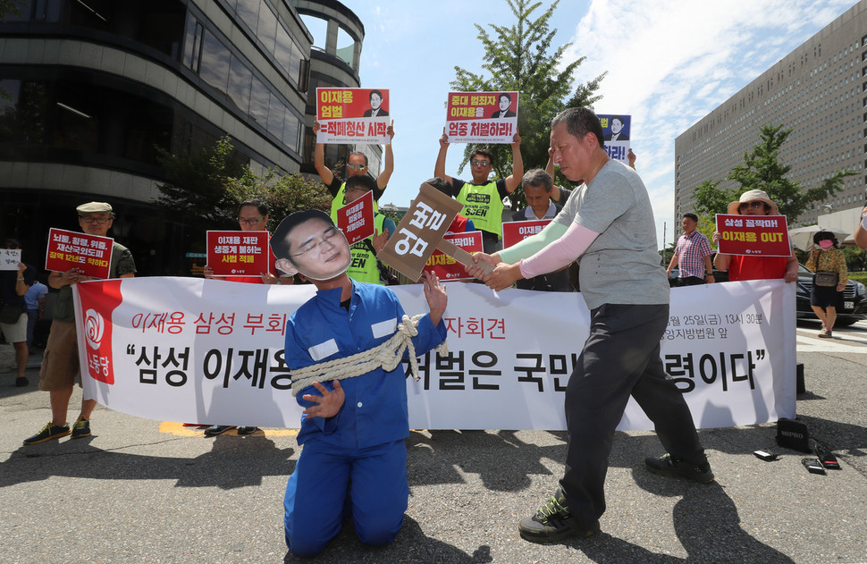 이재용 삼성전자 부회장의 1심 선고공판일인 25일 오후 서울 서초구 서울중앙지법 앞에서 노동당 당원들이 부회장의 처벌을 촉구하는 행위극을 하고 있다. 신소영 기자 viator@hani.co.kr