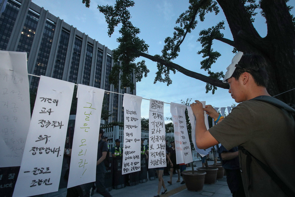 26일 오후 서울 종로구 정부서울청사 정문 앞에서 전국기간제교사연합회원들이 기간제교사 정규직 전환 촉구 집회를 마친 뒤 메시지를 적은 종이를 매달고 있다. 연합뉴스