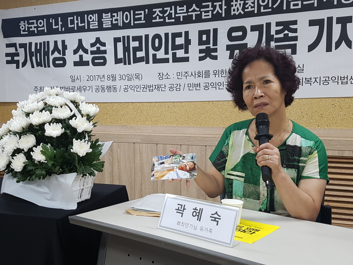 30일 서울 서초동 민주사회를위한변호사모임 사무실에서 열린 ‘고 최인기님의 사망사건 국가배상 소송 대리인단 및 유가족 기자회견’에서 고 최씨의 부인 곽혜숙씨가 고인의 사진을 들어보이고 있다.