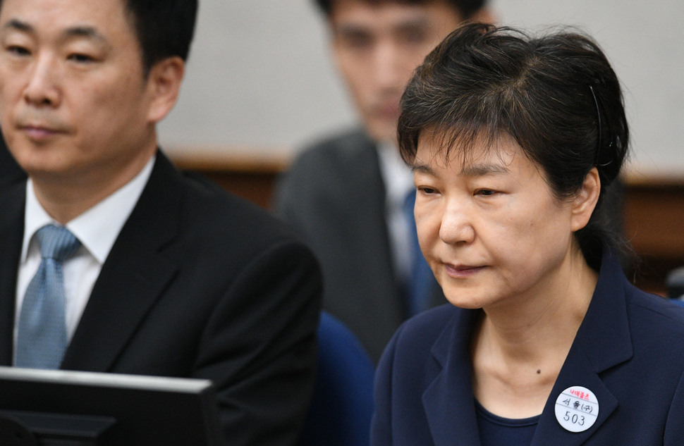 박근혜 전 대통령이 지난달 23일 왼쪽 옷깃에 수인번호 &#39;503번&#39;을 달고 서울중앙지법 417호 대법정에서 재판 시작을 기다리고 있는 모습.  사진공동취재단
