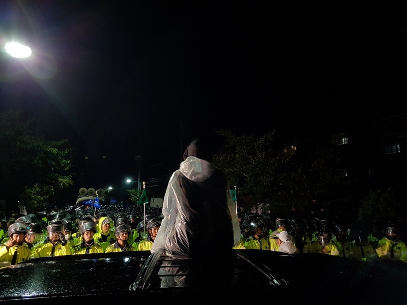 7일 새벽 경북 성주군 초전면 소성리 회관 앞 도로에서 연대자가 승용차 지붕에 앉아 경찰을 바라보고 있다. 성주/김일우 기자 cooly@hani.co.kr