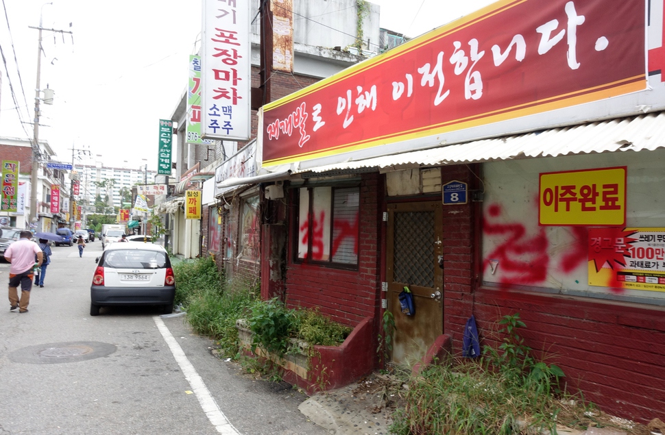 뉴타운 지구 해제 뒤 49층짜리 주상복합단지가 들어설 예정인 경기도 고양시 일산서구 일산동의 상가들에 15일 ‘철거’ ‘이주 완료’ 등 벽글씨와 펼침막 등이 어지럽게 나붙어 있다. 박경만 기자