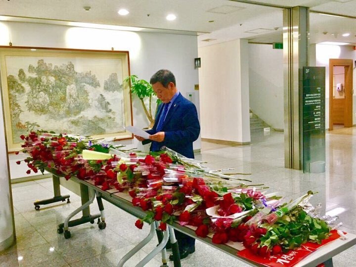 윤장현 광주광역시장이 지난 5월22일 사회복지사들이 광주시장실 앞에 놓고 간 장미꽃다발 옆에 든 사연을 읽어보고 있다. 연대회의 제공