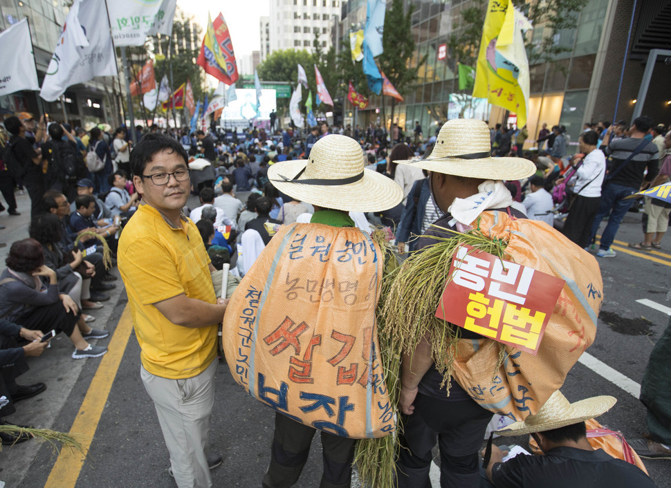 전국농민회총연맹 등 농민단체들이 23일 오후 서울 종로구 인근에서 ‘백남기 농민 뜻 관철과 농정개혁 실현을 위한 전국농민대회’를 열었다. 농민대회 일부 참가자들은 ‘쌀값 보장’을 요구하는 포대를 메고 대회에 참여했다. 연합뉴스